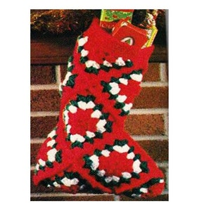 May include: Red, white, and green crocheted Christmas stocking with a geometric pattern. The stocking is filled with wrapped gifts.