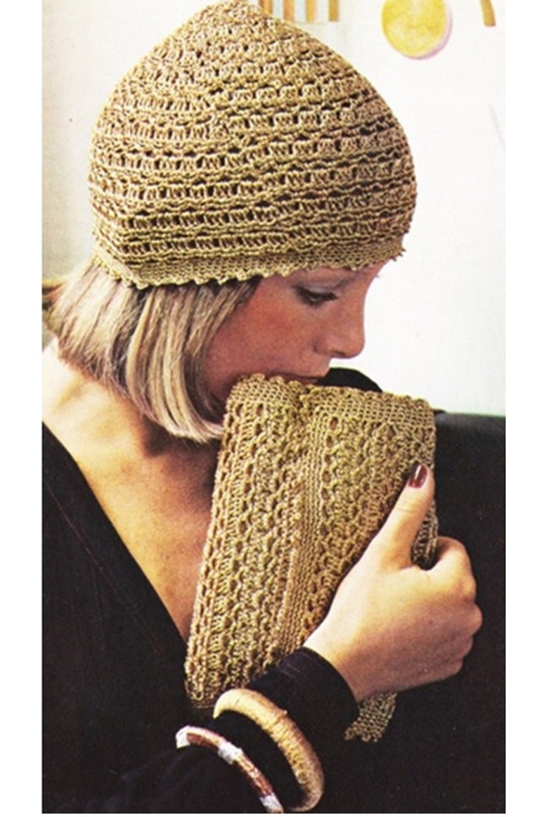 May include: A woman wearing a gold crocheted hat and holding a matching gold crocheted clutch.