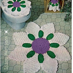 Puede incluir: Un conjunto de tres alfombras de baño de ganchillo con diseño de flores. Las alfombras son blancas con detalles verdes y morados. La alfombra más grande es una flor grande con ocho pétalos. Las alfombras más pequeñas son redondas y tienen un diseño de flor más pequeño en el centro. Las alfombras están hechas de hilo suave y son perfectas para agregar un toque de color y estilo a tu baño.