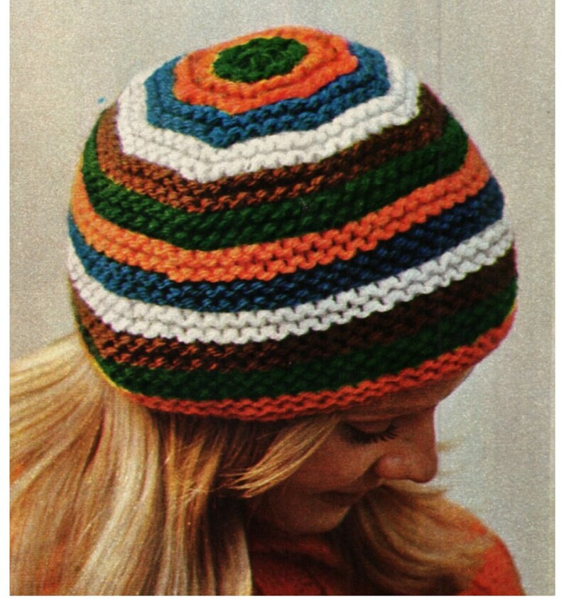 May include: A colorful striped knit hat with green, orange, blue, white, and brown stripes. The hat is made with a chunky yarn and has a simple, classic design.