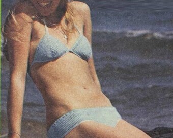 May include: A light blue crochet bikini top and bottom. The bikini top has a halter style with a triangle shape. The bikini bottom is a high-waisted style.