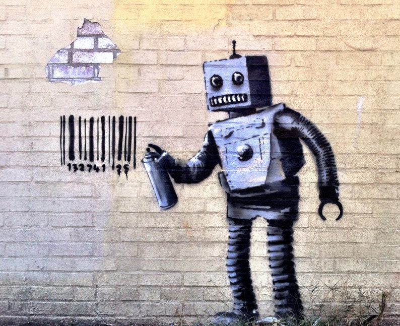 May include: A mural shows a robot spray-painting a barcode on a brick wall. The robot is grey and black, holding a spray can. The wall is light yellow with a section of missing bricks, revealing the underlying brickwork.