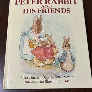 May include: A white book with a red title "Tales of Peter Rabbit and His Friends" featuring an illustration of Peter Rabbit and his friends. The book includes thirteen Beatrix Potter stories and illustrations.