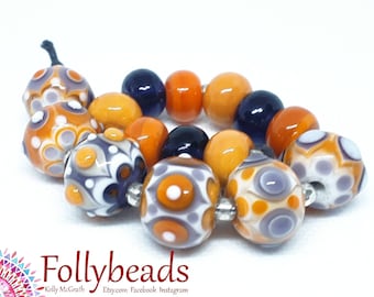 Handmade Lampwork Artisan glass bead set in transparent and opaque Purple, Orange and White.
