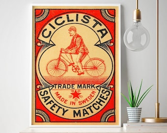 May include: Vintage red and white matchbox label with a black illustration of a cyclist riding a bicycle. The label reads "Ciclista Trade Mark Made in Sweden Safety Matches".