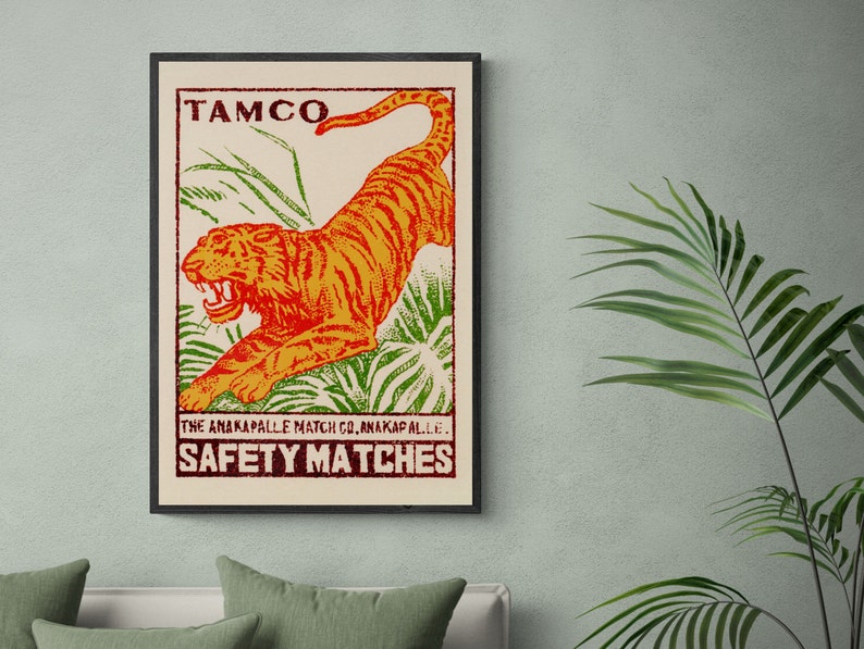 May include: Vintage matchbox label featuring a bright orange tiger leaping through green foliage. The label reads "TAMCO THE ANAKAPALLE MATCH CO. ANAKAPALLI. SAFETY MATCHES".