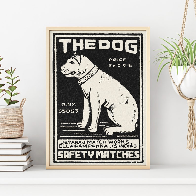 May include: Black and white vintage matchbox label with a cartoon dog illustration. The label reads "THE DOG", "PRICE Re 0 0 6", "R.N. 65057", "JEYARAJ MATCH WORKS ELLAIRAM PANNAL (S INDIA)", and "SAFETY MATCHES".