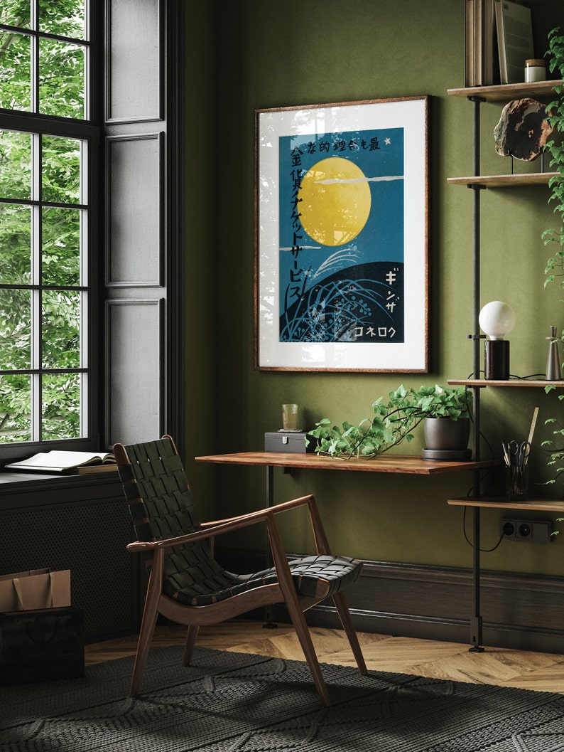 May include: A framed poster with a Japanese design featuring a large yellow moon, green grass, and the text "金色の夢を乗せて" in Japanese. The poster is hanging on a green wall in a room with a wooden desk, a chair, and a potted plant.