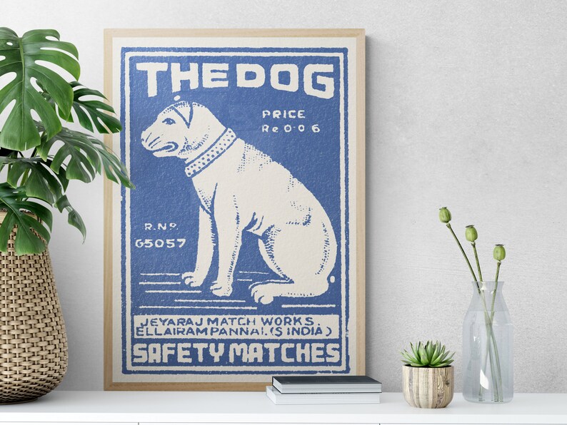 May include: Vintage blue and white matchbox label with a cartoon illustration of a dog and the text "THE DOG", "PRICE Re 0 0 6", "R.NO. 65057", "JEYARAJ MATCH WORKS. ELLAIRAM PANNAI. (S INDIA)", and "SAFETY MATCHES".