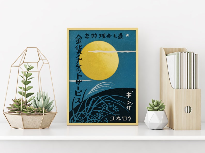 May include: A framed vintage poster with Japanese text and a yellow moon against a blue sky. The poster features a black silhouette of grass and a white cloud.