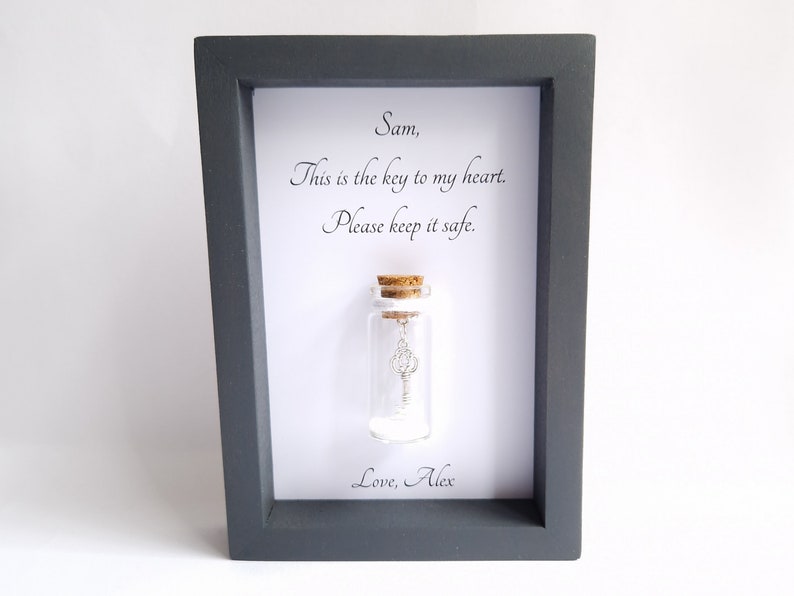 handmade personalised frame with a miniature glass bottle by under the blossom tree