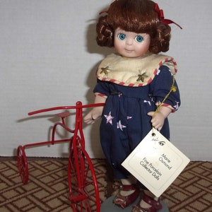 Muñeca de porcelana Marie Osmond &quot;Annie&quot; con triciclo - Serie Miracle Children de 24 cm