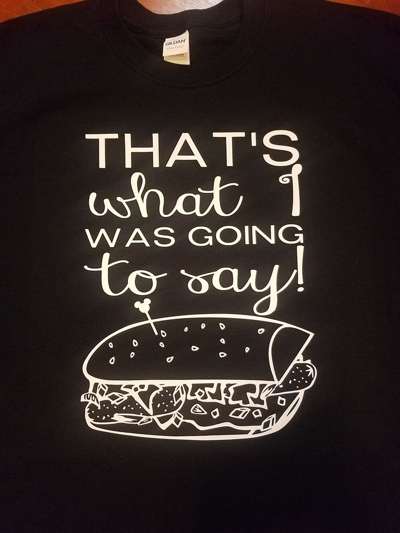 Op de afbeelding: Zwart t-shirt met witte tekst: "THAT'S what I was going to say!". Onder de tekst staat een witte lijntekening van een sandwich. Het t-shirt heeft een Gildan-label.