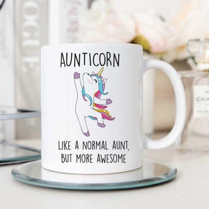May include: White ceramic mug with a colorful unicorn illustration and the text "Aunticorn Like a normal aunt, but more awesome".