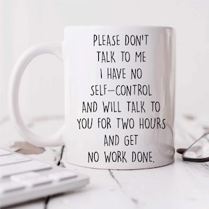 May include: White ceramic mug with a black humorous quote: "PLEASE DON'T TALK TO ME I HAVE NO SELF-CONTROL AND WILL TALK TO YOU FOR TWO HOURS AND GET NO WORK DONE." The mug has a curved handle and is on a white surface.