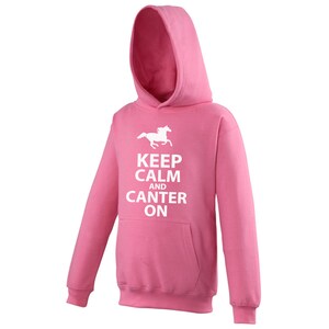 May include: Pink hooded sweatshirt with a white silhouette of a horse running and the text "Keep Calm and Canter On."