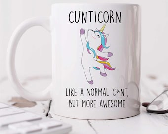 May include: White ceramic coffee mug with a colorful cartoon unicorn and the text "CUNTICORN LIKE A NORMAL C*NT, BUT MORE AWESOME".