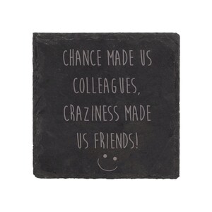 Può includere: Sottobicchiere in ardesia nera con il testo "Chance made us colleagues, craziness made us friends!" e un'emoticon sorridente.