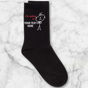May include: Black socks with a white stick figure and the text "I'd rather be YOUR TEXT HERE" in red.