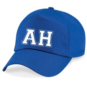 May include: A royal blue baseball cap with white felt letters spelling "AH" on the front.