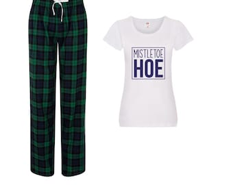 Könnte beinhalten: Ein Pyjama-Set mit einer Hose aus grün-blau kariertem Stoff mit Kordelzug und einem weißen T-Shirt. Das T-Shirt zeigt den Text "MISTLETOE HOE" in einem marineblauen Kasten.