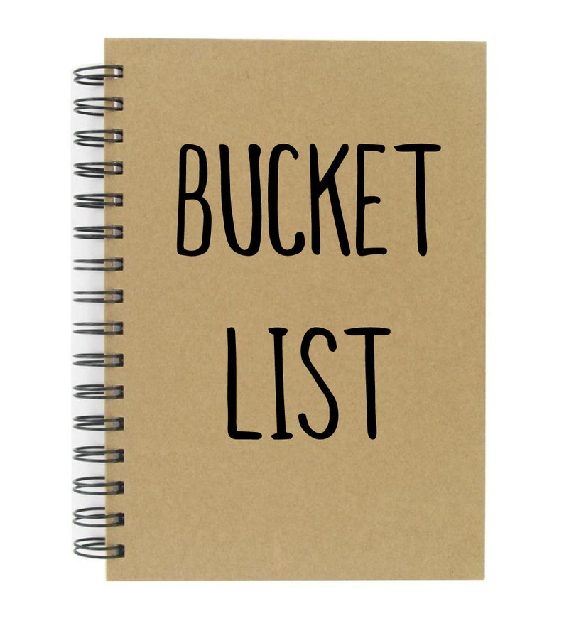 May include: A brown spiral bound notebook with the words "BUCKET LIST" written in black on the front cover.