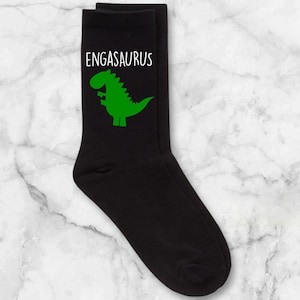May include: Black socks with a green dinosaur graphic and the text "ENGASAURUS" in white.