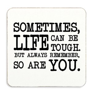 May include: White square coaster with black text that reads "Sometimes, life can be tough. But always remember, so are you."