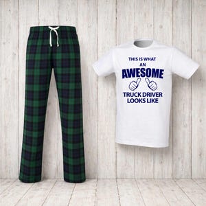 May include: A white t-shirt with the text "THIS IS WHAT AN AWESOME TRUCK DRIVER LOOKS LIKE" and a pair of green and navy plaid pajama pants with a drawstring waist. The shirt has blue text and thumbs up graphics.