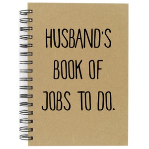 May include: A brown spiral bound notebook with the text "Husband's Book of Jobs To Do." printed in black.