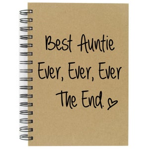 May include: A brown notebook with a spiral binding. The notebook has the words "Best Auntie Ever, Ever, Ever The End." written on it in black marker.