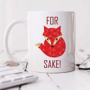 May include: White ceramic mug with a red fox illustration and the text "FOR SAKE!" printed on it.
