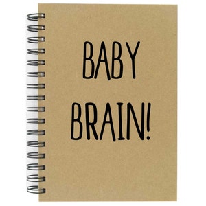 May include: A brown spiral bound notebook with the text "BABY BRAIN!" printed in black on the front cover.