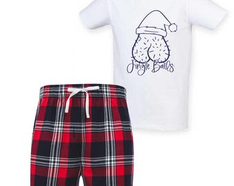 Könnte beinhalten: Weißes T-Shirt mit einer marineblauen Grafik eines Weihnachtsmützen-Hoden-Motivs und dem Text "Jingle Balls". Die Shorts sind rot, schwarz und weiß kariert mit weißem Kordelzug.