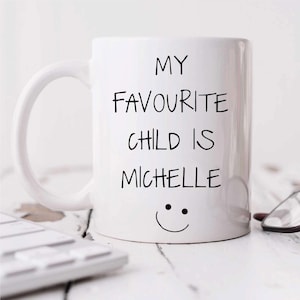 May include: White ceramic mug with black text that reads "My favorite child is Michelle" with a smiley face below the text.