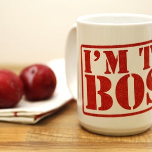 May include: White ceramic mug with a red graphic that says "I'M THE BOSS" in a bold, blocky font.