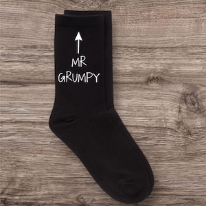 May include: Black socks with a white arrow pointing up and the text "MR GRUMPY" written below.
