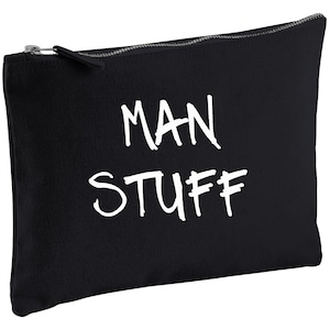 May include: Black canvas zippered pouch with white text that reads "MAN STUFF".
