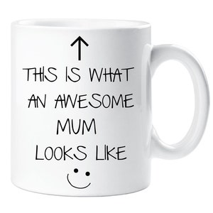 May include: White ceramic mug with black text that reads "This is what an awesome mum looks like" with an arrow pointing up and a smiley face at the bottom.