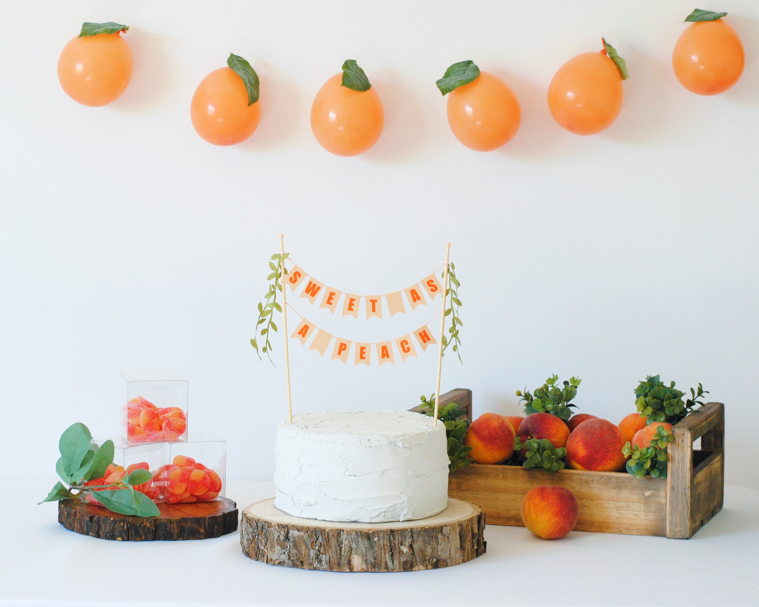 First Birthday Theme Ideas - sweet as a peach, sweet one birthday ideas - (box of peaches shown with a white cake with a sweet as a peach pennant banner on it.)