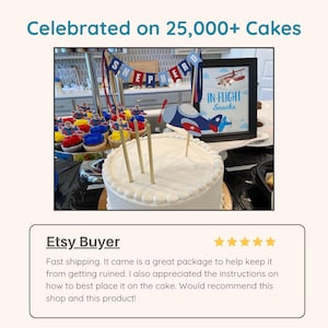 May include: A white frosted cake decorated with three gold candles and a blue and red airplane cake topper. A banner spelling SHEPHERD hangs above, alongside a framed sign reading IN-FLIGHT Snacks, and cupcakes with airplane-themed toppers.