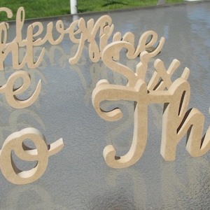 May include: A set of wooden numbers, including the numbers two, three, five, six, eight, and nine. The numbers are painted in a light brown color and have a cursive font.
