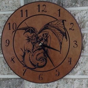 May include: A brown wooden clock with a black dragon design and black hands. The clock face has Roman numerals for the hours.