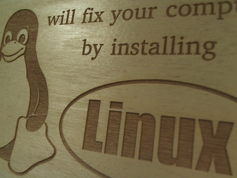 May include: A wooden sign with a cartoon penguin and the text "will fix your comp by installing Linux".