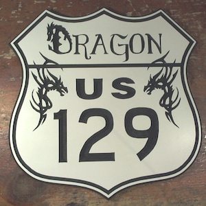May include: A white and black US Route 129 sign with a dragon design on each side. The sign reads "Dragon US 129".