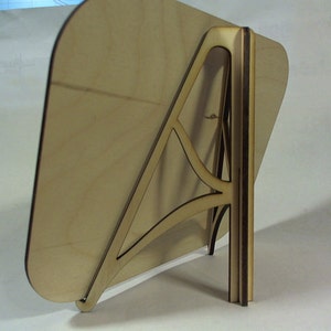 May include: A wooden easel stand with a light brown rectangular base and a dark brown support structure. The stand is designed to hold a picture or a sign.