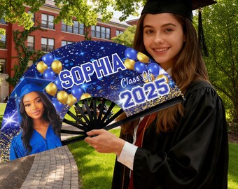 May include: A graduation fan with a black handle and a blue and gold design. The fan features the name "Sophia", the text "Class of 2025", and a photo of a graduate. The background includes blue and gold balloons.