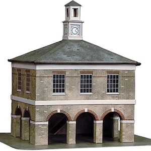 May include: A detailed architectural model of a two-storey building with a clock tower. The building features a grey roof, brick facade, and arched openings on the ground level. The clock tower has a clock face and a small steeple.