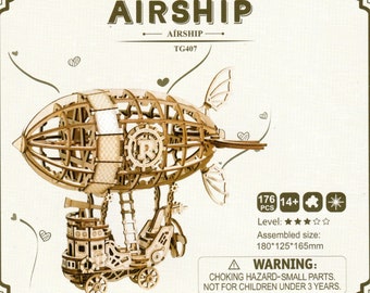 May include: Wooden airship model with intricate details. The model features a balloon-like structure with a gondola below, connected by a ladder. The text "AIRSHIP" is at the top. Assembled size is 180x125x165mm.