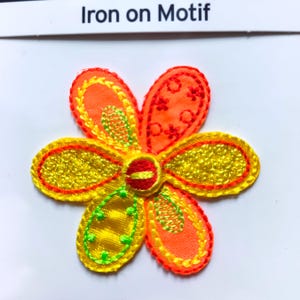 May include: Iron-on motif of a flower with six petals. The petals are yellow with orange and red stitching. The centre of the flower is red with yellow stitching.